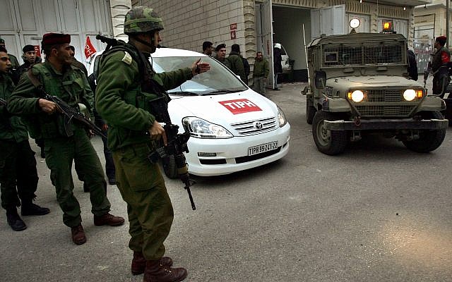 Los soldados se paran cerca de un automóvil utilizado por miembros del TIPH, Presencia Internacional Temporal en Hebrón el miércoles 8 de febrero de 2006. (Foto de AP / Emilio Morenatti)