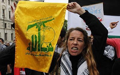 Una partidaria pro palestina sostiene una bandera del grupo Hezbolá, durante una marcha para protestar contra Israel en el centro de Londres, 31 de mayo de 2010. (Foto de AP / Lefteris Pitarakis)