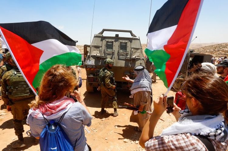 FOTO: "Turistas" protestan contra Israel cerca de Hebrón el 7 de julio de 2018. (Wisam Hashlamoun / Flash90)