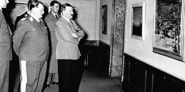 Durante la década de 1930 en Alemania, Hermann Goering y Adolph Hitler examinan una pintura en una exposición sobre arte degenerado (dominio público)