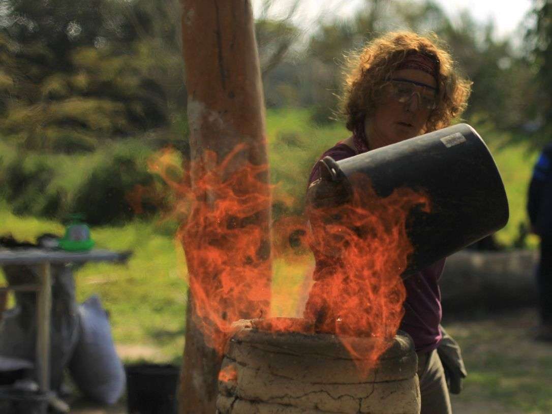 Haciendo hierro como hace 3.000 años: Agregando mineral al horno. Crédito: Ilan Assayag
