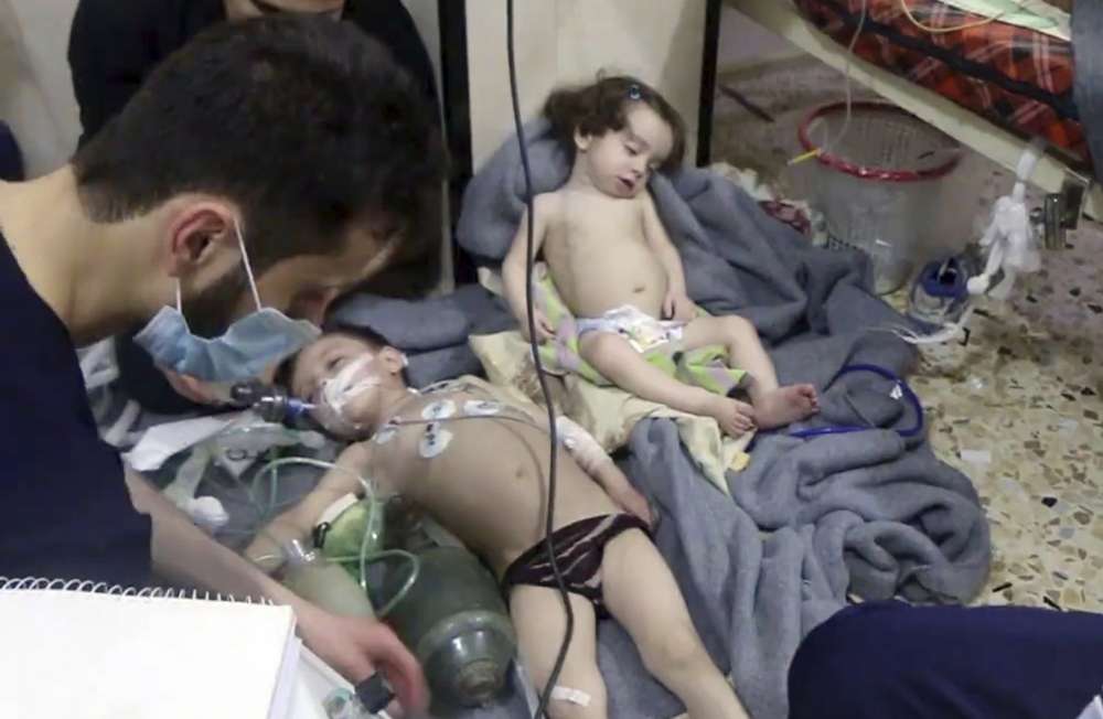 Trabajadores médicos que tratan a niños pequeños después de un ataque con gas venenoso en la ciudad de Douma, en la zona de Ghouta oriental, cerca de Damasco, Siria, en abril. 8, 2018 (Cascos Blancos de Defensa Civil Siria a través de AP)