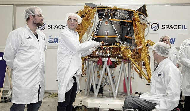 Yariv Bash, a la derecha, Yonatan Winetraub, en medio, y Kfir Damari, los fundadores de SpaceIL, insertando una cápsula del tiempo en la nave espacial Beresheet, 17 de diciembre de 2018 (Yoav Weiss)