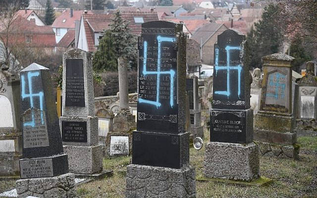 Una fotografía tomada el 19 de febrero de 2019, muestra esvásticas pintadas en tumbas en un cementerio judío en la ciudad francesa de Quatzenheim, cerca de la frontera alemana (Frederick FLORIN / AFP)