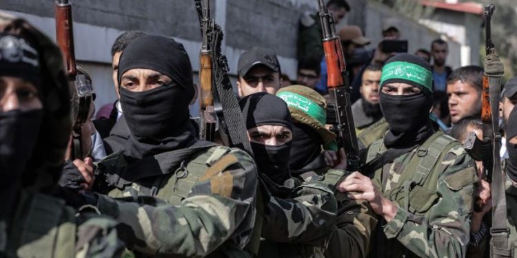 Terroristas armados de Hamas enmascarados asisten al funeral de Mahmoud al-Nabaheen, de 24 años, en el campamento de refugiados de Bureij, en el centro de la Franja de Gaza, el 23 de enero de 2019. (MAHMUD HAMS / AFP)