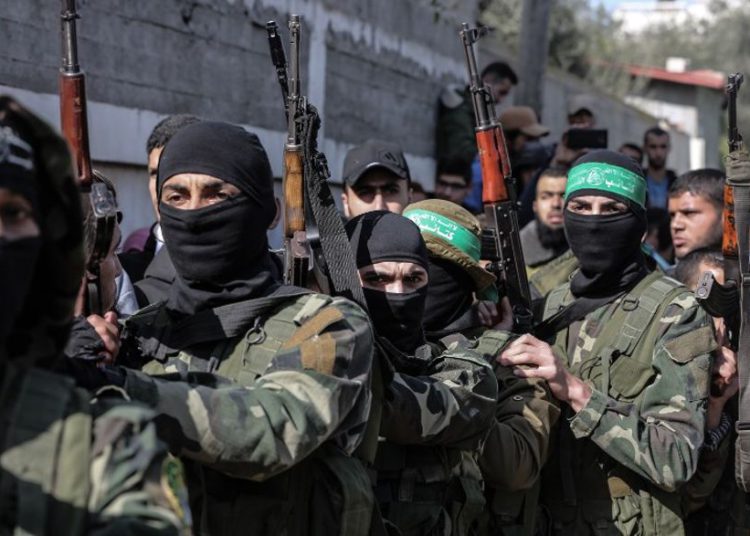 Terroristas armados de Hamas enmascarados asisten al funeral de Mahmoud al-Nabaheen, de 24 años, en el campamento de refugiados de Bureij, en el centro de la Franja de Gaza, el 23 de enero de 2019. (MAHMUD HAMS / AFP)