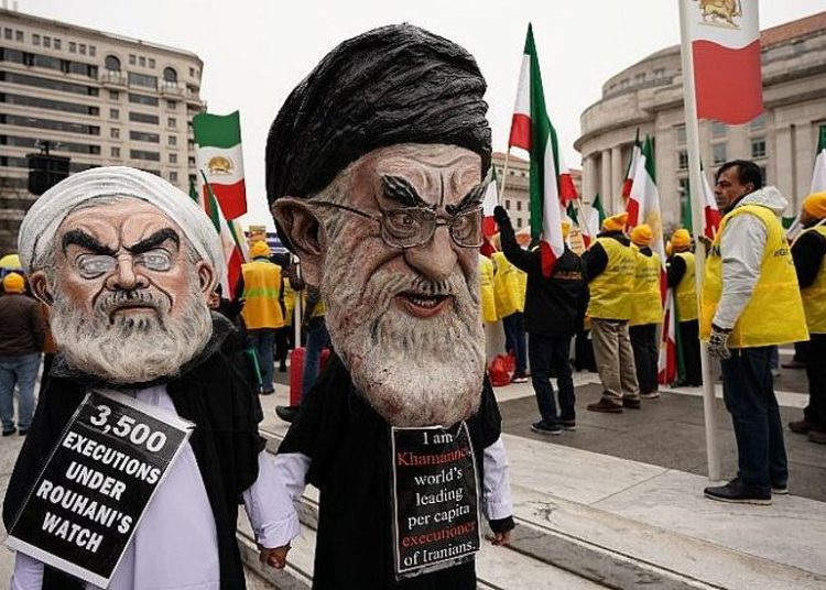Las efigies del presidente iraní Hassan Rouhani (L) y del líder supremo de Irán, Ayatollah Ali Khamenei (R), marchan con la Organización de Comunidades Iraní-Americanas durante un mitin en apoyo de "los levantamientos nacionales en Irán por el cambio de régimen" el 8 de marzo de 2019. Washington, DC (Mandel NGAN / AFP)