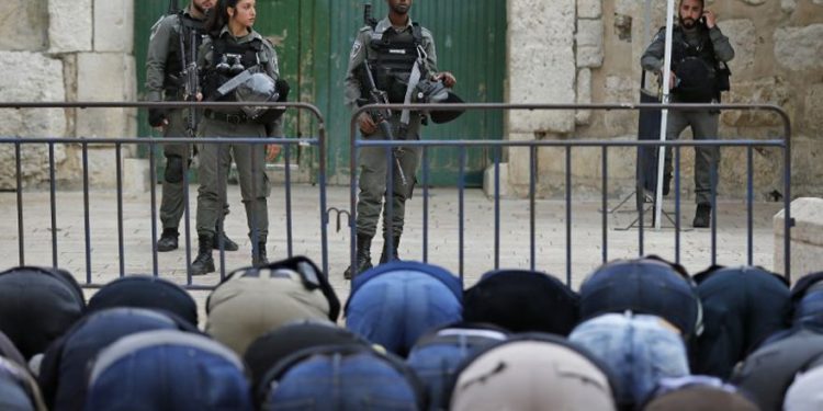 Los fieles musulmanes rezan frente a una barrera después de que la Policía Fronteriza cerró una de las entradas al complejo del Monte del Templo en la Ciudad Vieja de Jerusalem, que alberga la Mezquita de Al-Aqsa, el 12 de marzo de 2019. (Ahmad Gharabli / AFP)