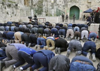 Los fieles musulmanes palestinos rezan frente a una barrera después de que la policía fronteriza israelí cerró una de las entradas del complejo del Monte del Templo en la ciudad vieja de Jerusalem el 12 de marzo de 2019. (Ahmad Gharabli / AFP)