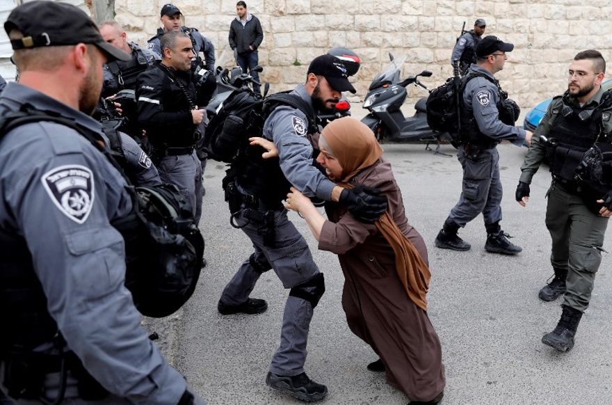 Un policía israelí retiene a una mujer palestina en las afueras de la Ciudad Vieja en Jerusalén después de que la policía cerró la entrada al complejo de la mezquita al-Aqsa en el Monte del Templo luego de un ataque con una bomba incendiaria contra un puesto de policía en el sitio, el 12 de marzo de 2019. (Ahmad Gharabli / AFP)