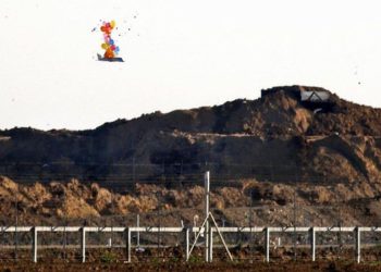 Esta fotografía del 22 de marzo de 2019 muestra globos que transportan un objeto en forma de avión no tripulado que vuela sobre la frontera con Israel al este de la ciudad de Gaza, después de que fue lanzado por palestinos durante los enfrentamientos a lo largo de la valla de seguridad. (Dijo Khatib / AFP)