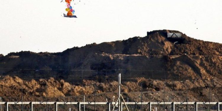 Esta fotografía del 22 de marzo de 2019 muestra globos que transportan un objeto en forma de avión no tripulado que vuela sobre la frontera con Israel al este de la ciudad de Gaza, después de que fue lanzado por palestinos durante los enfrentamientos a lo largo de la valla de seguridad. (Dijo Khatib / AFP)