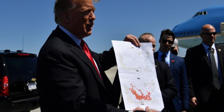 El presidente de los EE. UU., Donald Trump, muestra un mapa que, según él, indica el final de ISIS, cuando llega al Aeropuerto Internacional de Palm Beach en Florida el 22 de marzo de 2019. (Foto de Nicholas Kamm / AFP)