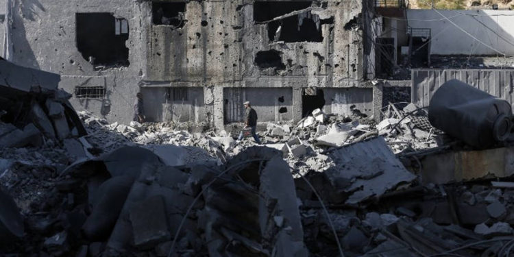 Una fotografía tomada el 26 de marzo de 2019, muestra a un hombre palestino abriéndose camino entre los escombros de un edificio en la ciudad de Gaza, después de que los ataques aéreos israelíes impactaron en decenas de sitios en la Franja durante la noche en respuesta al lanzamiento de cohetes desde el enclave palestino. (Mahmud Hams / AFP)