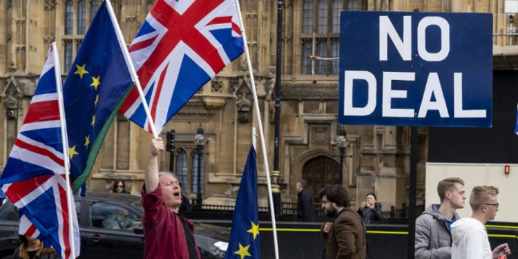 Activistas anti-Brexit exhiben las banderas de la Unión y de la UE mientras se manifiestan frente a las Casas del Parlamento en Westminster, Londres, el 28 de marzo de 2019. (Niklas Halle'n / AFP)