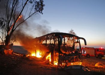 Una fotografía tomada el 12 de noviembre de 2018 muestra un autobús incendiado luego de ser alcanzado por un cohete lanzado desde la Franja de Gaza. (Crédito de la foto: MENAHEM KAHANA / AFP)