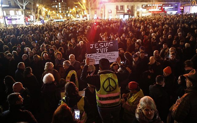 Un hombre que lleva un chaleco amarillo sostiene un cartel que dice "Soy judío", durante una reunión en la plaza de la República para protestar contra el antisemitismo, en París, Francia, el 19 de febrero de 2019. (Foto AP / Thibault Camus