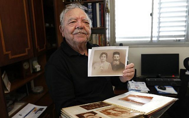 Samy Gryn, 78, sobreviviente franco-israelí del Holocausto, muestra una vieja foto de sus familiares en Tel Aviv, el 25 de febrero de 2019. (Menahem Kahana / AFP)