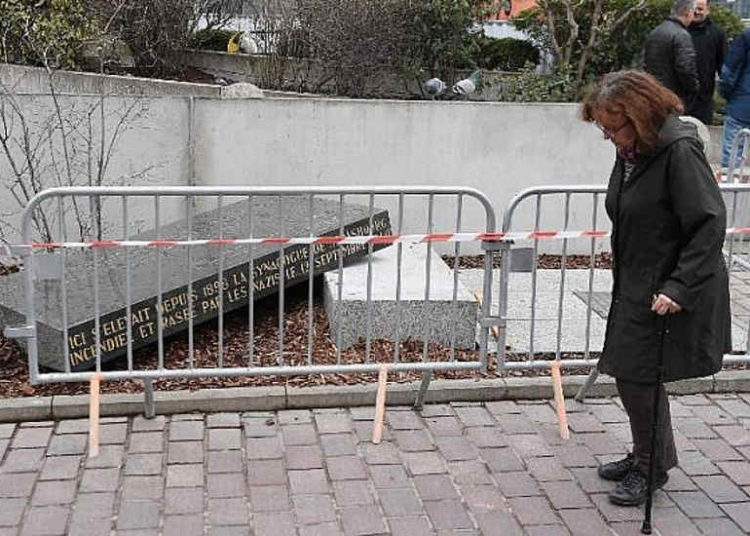Una persona pasa junto a la piedra conmemorativa que marca el sitio de la Sinagoga Vieja de Estrasburgo, que fue destruida por los nazis en la Segunda Guerra Mundial, después de que fue destruida durante la noche del 2 de marzo de 2019 en Estrasburgo, este de Francia. (FREDERICK FLORIN / AFP)