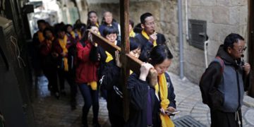 Los peregrinos católicos chinos llevan una cruz de madera a lo largo de la Via Dolorosa en la Ciudad Vieja de Jerusalem durante la procesión del Viernes Santo el 19 de abril de 2019. (Thomas Coex / AFP)