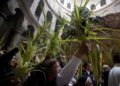 Monjes y fieles católicos reparten ramas de olivos en Jerusalem pese a las restricciones