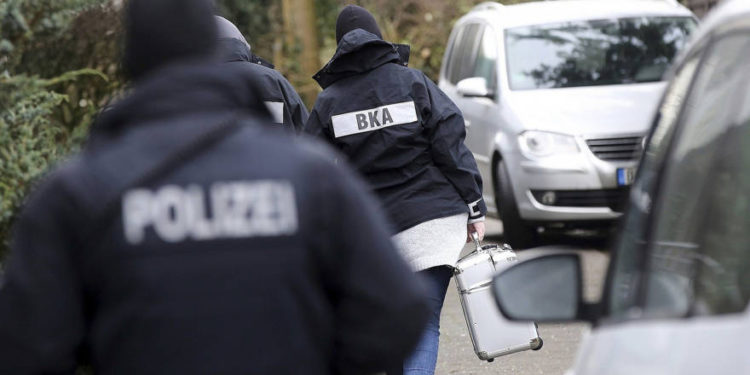 Ilustrativo: El oficial de policía camina entre los autos durante una redada en el pueblo de Meldorf, Alemania, 30 de enero de 2019. (Bodo Marks / dpa via AP)