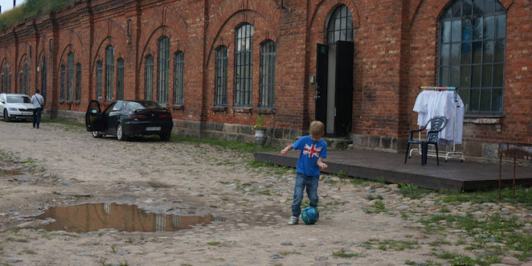 Un niño jugando al fútbol en la entrada del antiguo campo de concentración conocido como el Séptimo Fuerte en Kaunas, Lituania, el 12 de julio de 2016. (JTA / Cnaan Liphshiz)