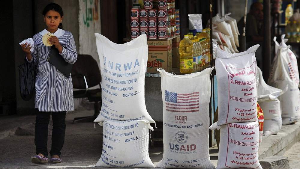 Una alumna árabe pasa por delante del Organismo de Obras Públicas y Socorro de las Naciones Unidas (UNRWA), y USAID, ayuda humanitaria el 6 de junio de 2010 en el campo de refugiados de Shatie, en la ciudad de Gaza. (Foto AP / Lefteris Pitarakis, Archivo)