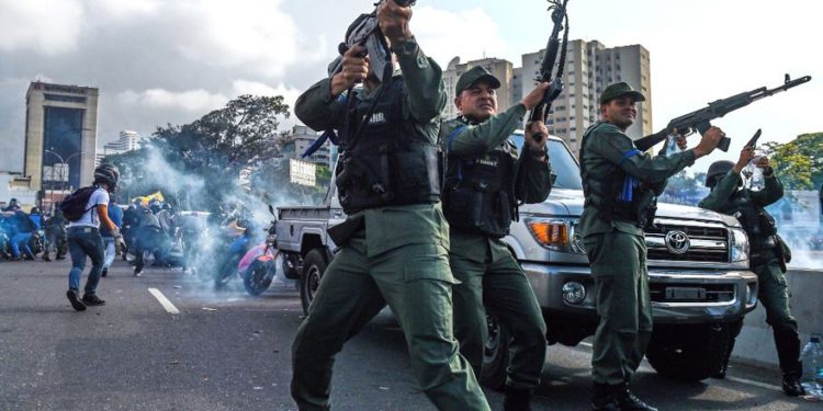 Los miembros de la Guardia Nacional Bolivariana que se unieron al líder opositor venezolano y al autoproclamado presidente Juan Guaido dispararon al aire para repeler a las fuerzas leales al presidente Nicolás Maduro, quien llegó para dispersar una manifestación cerca de la base militar de La Carlota en Caracas el 30 de abril de 2019. (Federico Parra / AFP)