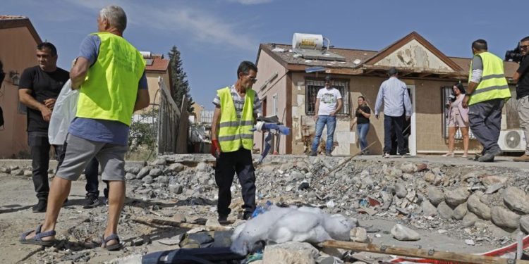 La gente inspecciona los daños en una casa en la ciudad de Beersheba, en el sur de Israel, el 5 de mayo de 2019, luego de haber sido alcanzada por un cohete desde Gaza. (Ahmad GHARABLI / AFP)