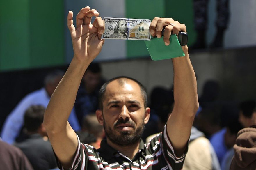 Un hombre palestino tiene un billete de $ 100, parte de $ 480 millones en ayuda asignada por Qatar, en la ciudad de Gaza el 13 de mayo de 2019. (MOHAMMED ABED / AFP)