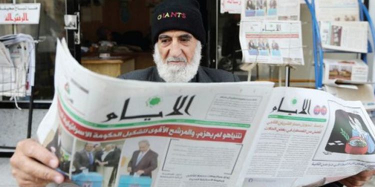 Un hombre de Gaza lee un periódico, con las elecciones israelíes en su portada, en Khan Younis, el 18 de marzo .. (Crédito de la foto: IBRAHEEM ABU MUSTAFA / REUTERS)