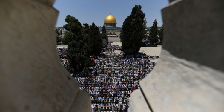 La Cúpula de la Roca se ve en el fondo mientras los palestinos rezan el primer viernes de Ramadán en 2018. (Crédito de la foto: AMMAR AWAD / REUTERS)