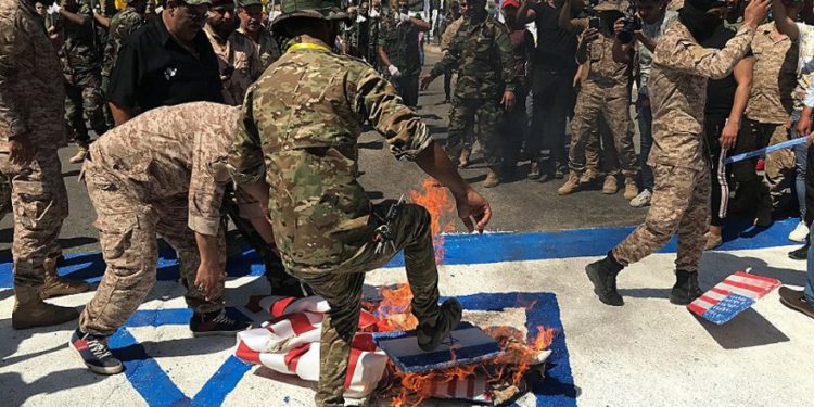 Las Fuerzas de Movilización Popular de Irak queman representaciones de banderas estadounidenses e israelíes durante el Día de Quds, en Bagdad, el viernes | Foto: AP / Ali Abdul Hassan