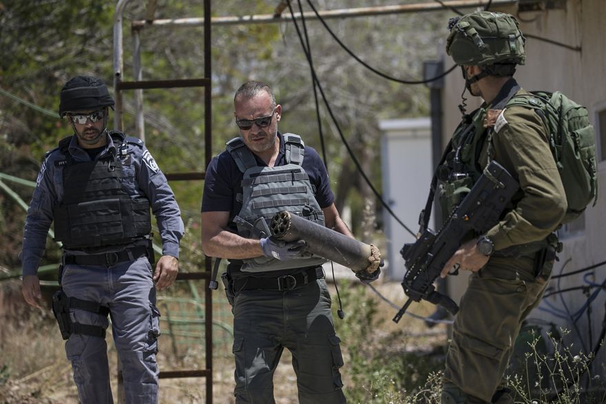 Un zapador de la policía israelí sostiene parte de un cohete Qassam explotado disparado desde la Franja de Gaza en una aldea cerca de la frontera de Gaza, 5 de mayo de 2019. (AP / Tsafrir Abayov)
