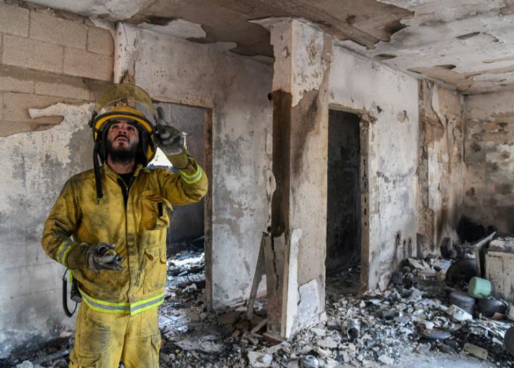 Los bomberos observan los daños causados ​​por un incendio en Kibbutz Harel, el 24 de mayo de 2019. (Noam Revkin Fenton / Flash90)