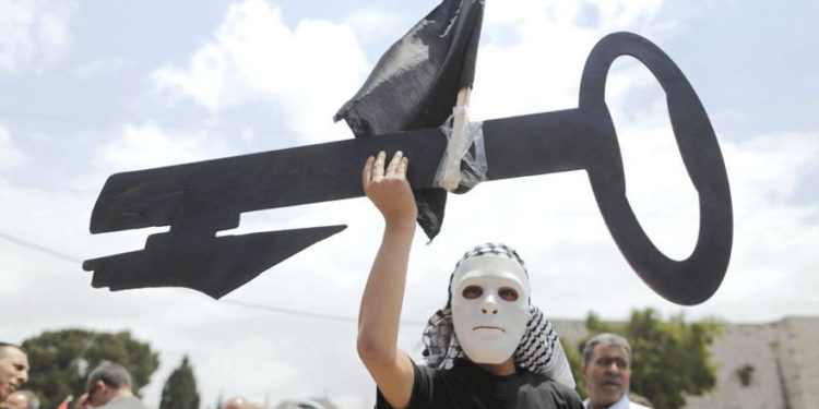 Un palestino que usa una máscara sostiene un corte de llave durante un mitin antes del 'Día de la Nakba' en Belén en 2015. (Crédito de la foto: REUTERS)