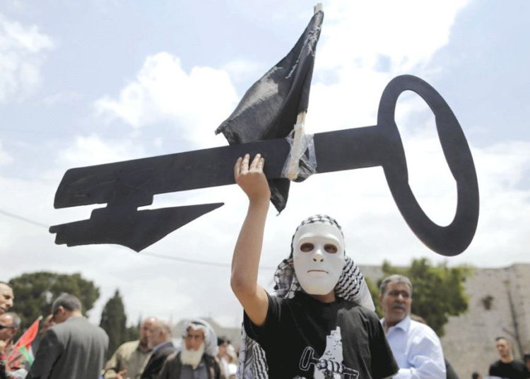 Un palestino que usa una máscara sostiene un corte de llave durante un mitin antes del 'Día de la Nakba' en Belén en 2015. (Crédito de la foto: REUTERS)