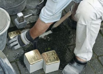 El artista Gunter Demnig coloca Stolpersteine, pequeñas placas de bronce que conmemoran a las víctimas de los nazis, en Colonia en 2015. (Crédito de la foto: KARIN RICHERT)