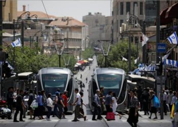 Los peatones cruzan una calle al lado de los tranvías del tren ligero en Jerusalem el 11 de mayo de 2017. Imagen tomada el 11 de mayo de 2017.. (Crédito de la foto: REUTERS / AMIR COHEN)