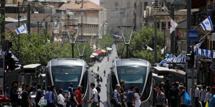 Los peatones cruzan una calle al lado de los tranvías del tren ligero en Jerusalem el 11 de mayo de 2017. Imagen tomada el 11 de mayo de 2017.. (Crédito de la foto: REUTERS / AMIR COHEN)