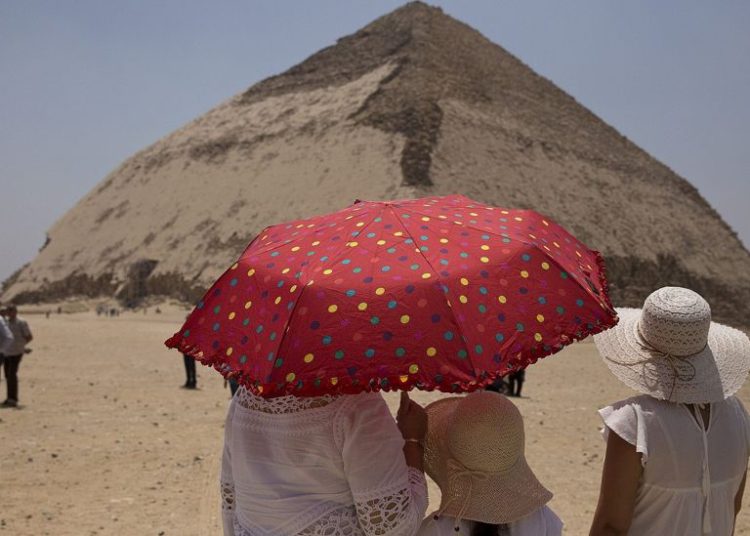 Un miembro de una delegación internacional dibuja el sitio de la pirámide doblada durante un evento que abre la pirámide y sus satélites para los visitantes en Dashur, Egipto, sábado 13 de julio de 2019 (Foto AP / Maya Alleruzzo)