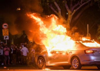 Se ve un automóvil en llamas durante una protesta después de la muerte del etíope de 19 años, Salomón Tekah, quien fue asesinado a tiros hace unos días en Kiryat Haim por un oficial de policía fuera de servicio, en Tel Aviv, el 2 de julio de 2019. (Flash90)