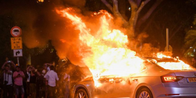 Se ve un automóvil en llamas durante una protesta después de la muerte del etíope de 19 años, Salomón Tekah, quien fue asesinado a tiros hace unos días en Kiryat Haim por un oficial de policía fuera de servicio, en Tel Aviv, el 2 de julio de 2019. (Flash90)