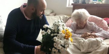 Krystyna Danko recibió flores de Jonny Daniels en su apartamento en Varsovia, Polonia, en su 102 cumpleaños, el 9 de julio de 2019. (De las Profundidades a través de JTA)