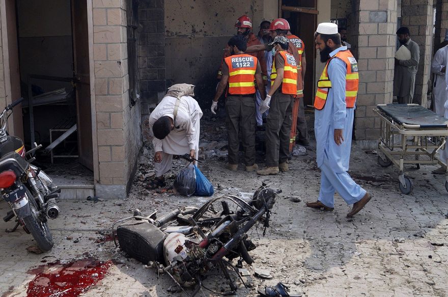 Funcionarios de seguridad y trabajadores de rescate pakistaníes se reúnen en el lugar de un atentado suicida en una entrada de un hospital en Dera Ismail Khan, Pakistán, 21 de julio de 2019. (AP Photo / Ishtiaq Mahsud