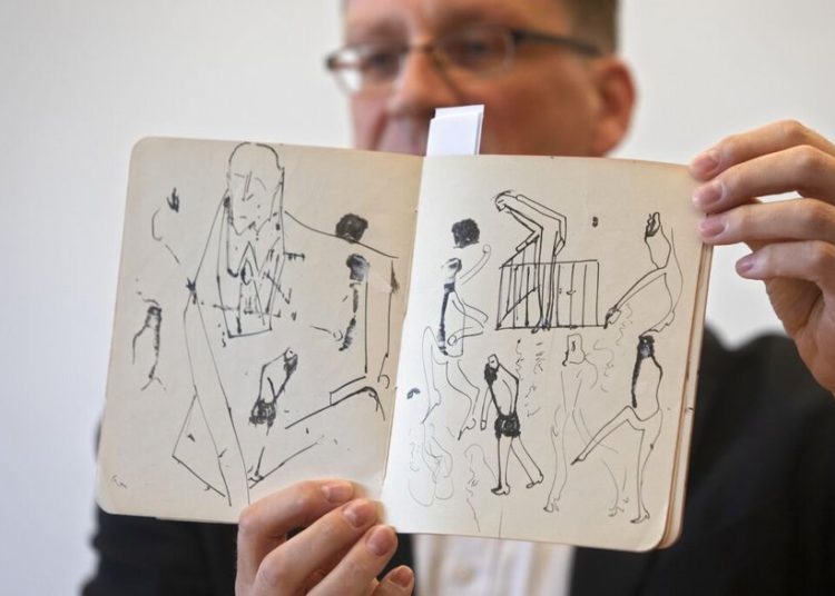 Un funcionario de la Biblioteca Nacional muestra dibujos del famoso autor alemán Franz Kafka en una conferencia de prensa en Jerusalem, el miércoles | Foto: AP / Sebastian Scheiner