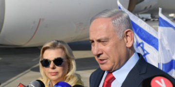 El primer ministro Benjamin Netanyahu habla con los periodistas antes de embarcarse en un viaje a Ucrania con su esposa, Sara, el 18 de agosto de 2019. (Crédito de la foto: AMOS BEN-GERSHOM / GPO)
