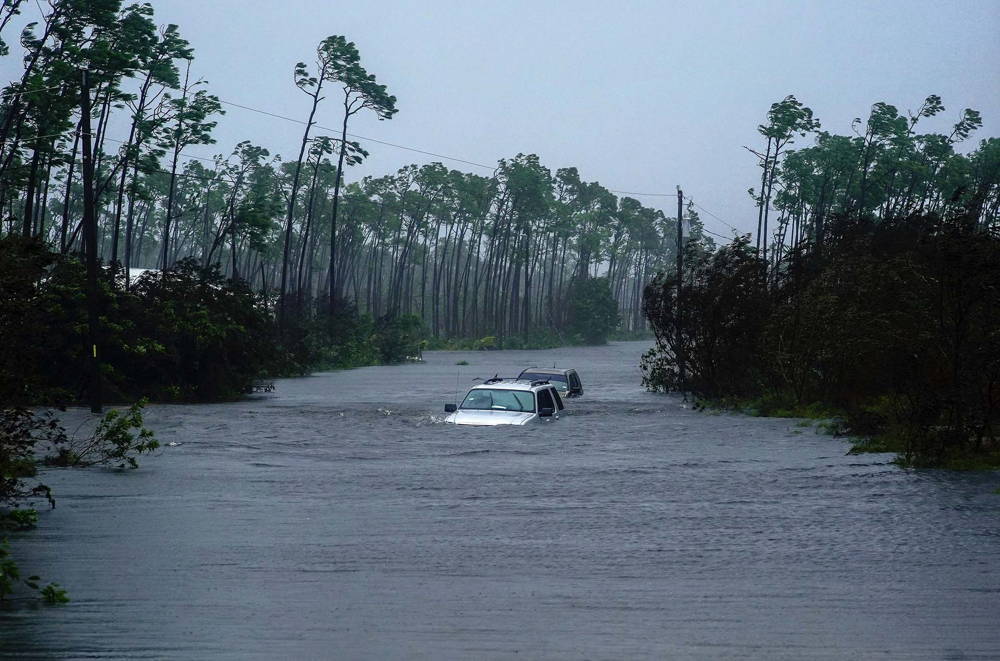 Dos automovilistas intentan pasar por calles inundadas (AP Photo/Ramon Espinosa)