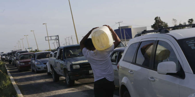 Un hombre lleva un contenedor de gasolina mientras otros autos esperan en la fila para comprar gasolina en una estación de servicio de Pemex en San José del Cabo, después del huracán Odile en Baja California. (crédito de la foto: REUTERS)